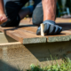 A contractor building a wooden deck in a backyard with natural wood materials